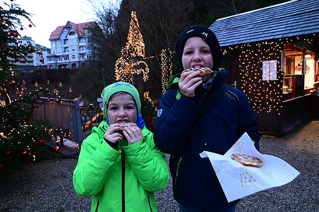 Mats und Jonas Kohler sind mit Eltern und Großeltern auf dem Triberger Weihnachtszauber und lassen sich eine Waffel schmecken. ...