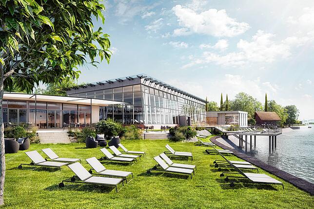 Diese Visualisierung zeigt den Außenbereich mit Therme-Hauptbau und Sauna-Anbau im Hintergrund. Die charakteristischen ...