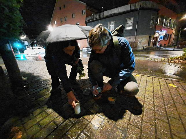 Das Paar Maggie und Julika Funk putzen die Stolpersteine. Zu den Steinen stellen sie im Anschluss eine Kerze, sowie sechs weiße Rosen.