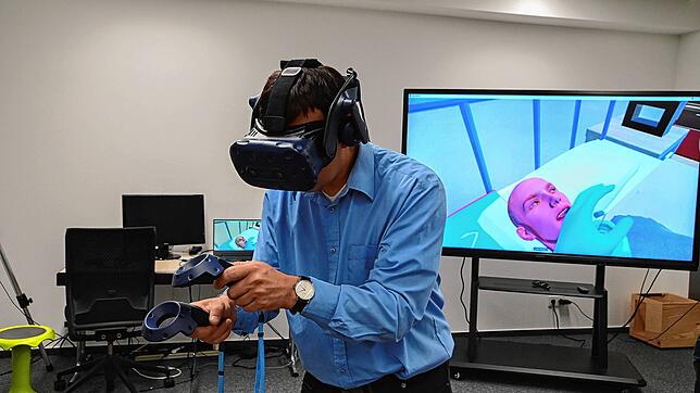 Christoph Gawel von der Firma Imsimity führt das Cyber Care Lab vor. Was er in der VR-Brille sieht, wird auf den großen Monitor im ...