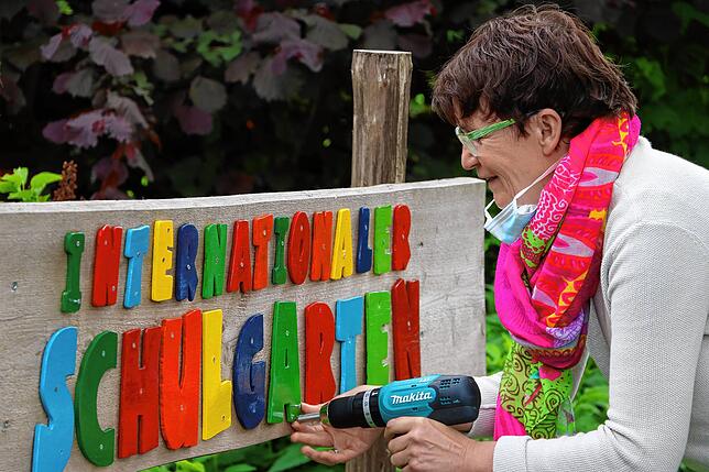 Nun ist auch der bunte Schriftzug des Internationalen Schulgartens wieder komplett. Jutta Schär ersetzte fehlende Buchstaben.