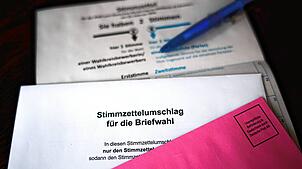 Briefwahlunterlagen liegen auf einem Tisch.
