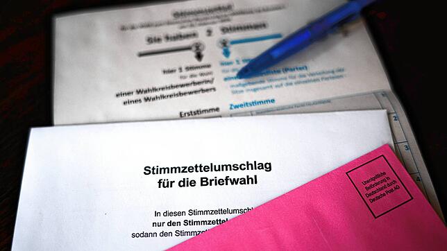 Briefwahlunterlagen liegen auf einem Tisch.
