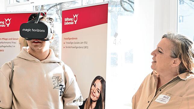 Yvonne Denzler demonstriert Alexandru Tripon die VR-Brille ihrer Einrichtung