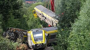 Mit einem Kran wurden am Montagabend die ersten Waggons des entgleisten Zugs geborgen.