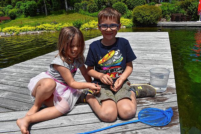 Rosa (4) und Elia (7) beschäftigen sich am Dienstag, 18. Juni, mit Molche fangen auf dem Steg des Naturena-Badesee in Birkendorf. ...