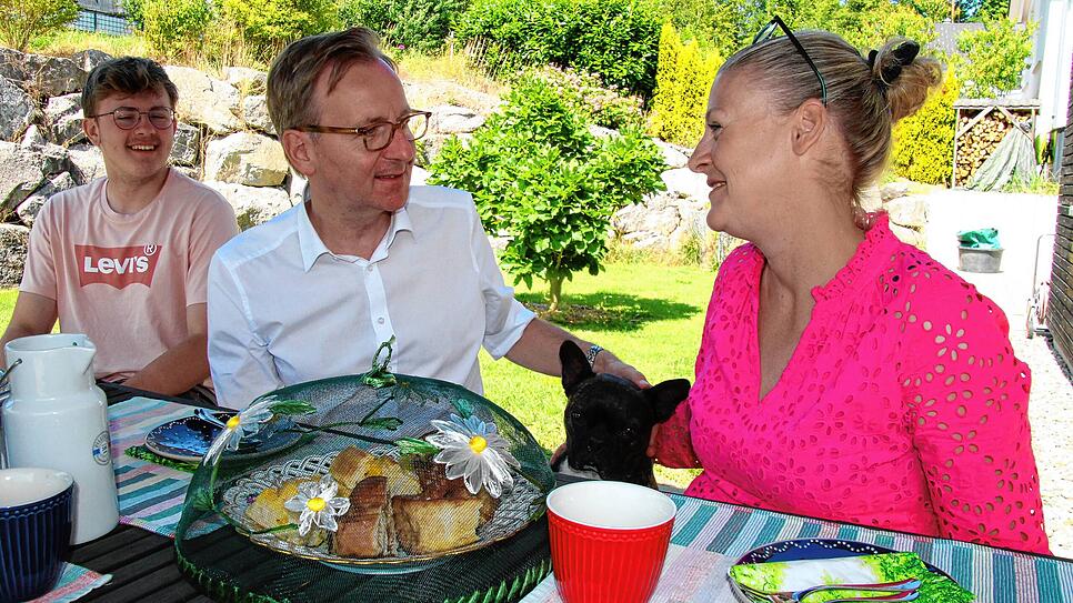 OB Philipp Frank mit seinem ältesten Sohn Julius, der französischen Bulldogge Oscar und seiner Frau Tanja beim Kaffee trinken im Garten. ...