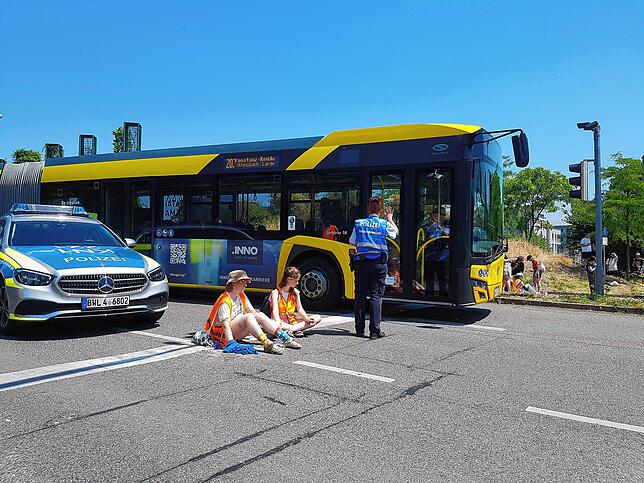 Ein Bus muss um die beiden Aktivistinnen herumgelotst werden.