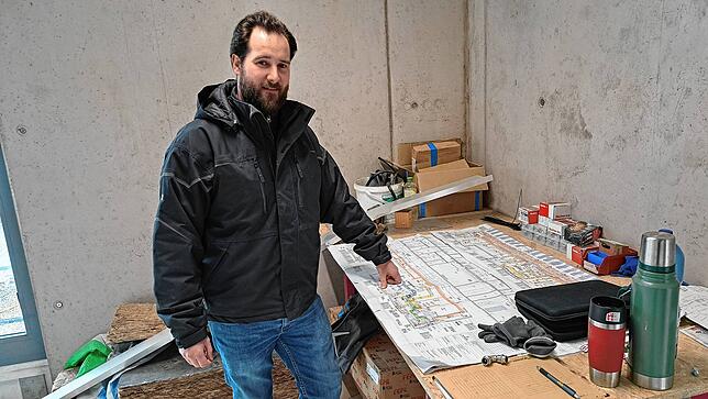 Bauleiter Christoph Marquart vom Industrie- & Gewerbebauer i+R mit den Plänen für die neue Turnhalle – hier im geplanten Fitnessraum.