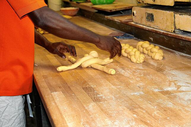 Vor neun Monaten hat Abdoulie Camara seine Ausbildung zum Bäcker begonnen. Routiniert flechtet er die Hefezöpfe.