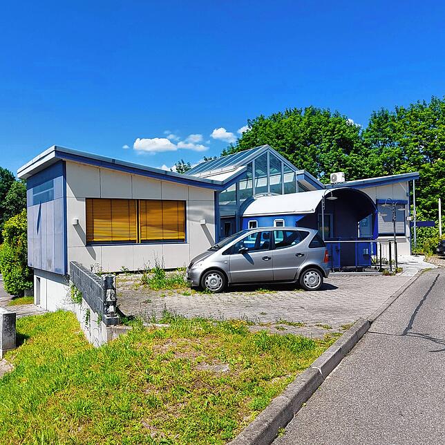 Direkt hinter diesem Gebäude hält der Seehas am Bahnhof Wollmatingen entstehen. Zudem verläuft dahinter der Radweg.