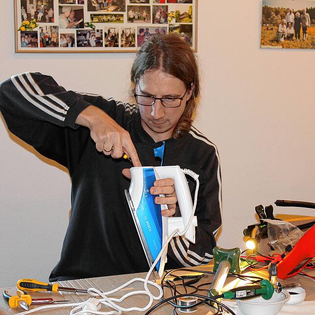 Simon Wawroschek zerlegt ein Bügeleisen und sucht nach der Ursache eines Defekts.