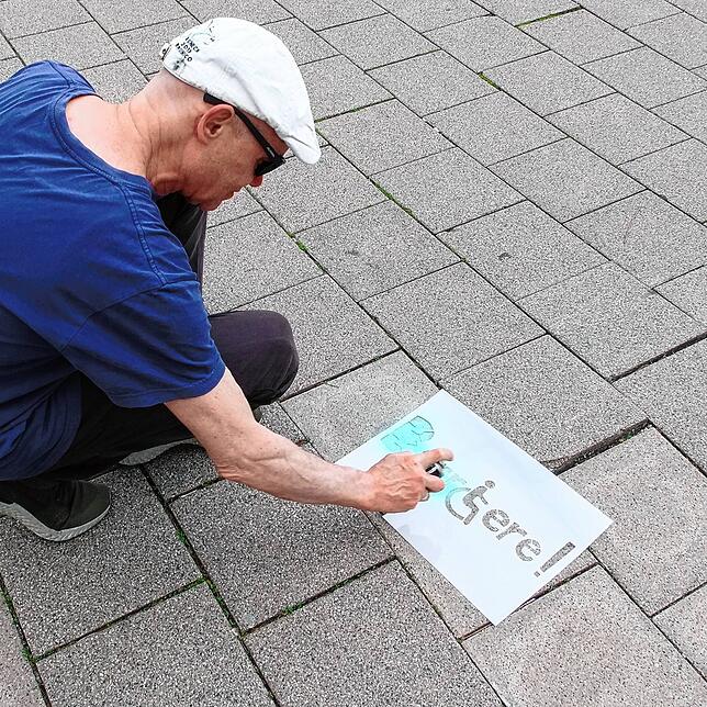 Herbert Reuter markiert eine Stolperfalle mit Kreide.