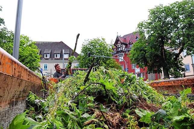 Christian Bühler, Mitarbeiter des Betriebshofs in Überlingen, wuchtet Äste und Laub in einen Container.