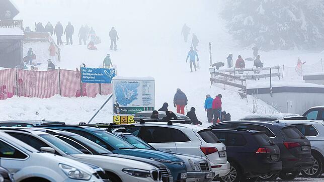 Menschen stehen im dichten Nebel nahe dem Skilift am Haldenköpfle in Oberried, der Parkplatz vor der geschlossenen Liftanlage ist voll. ...