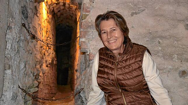 Burgherrin Julia Naeßl-Doms neben der nachträglich in den Felsen getriebenen Querverbindung. Am Ende des ausgeleuchteten Stollens kann ...
