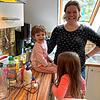 Tagesmama Nadine Klopcke stellt mit Tageskind Cecilia und Besucherkind Aliya Glitzerflaschen in der Küche her.
