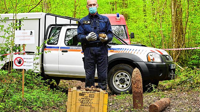 Ein Mitarbeiter der französischen Kampfmittelbeseitigung im Wald am Winterbergtunnel. Neben ihm stehen zwei Granaten, die nicht ...