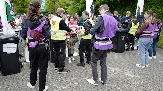 In lila Weste: Helfer vom Team Ticked Connected geben die Bändel für die Festival-Besucher aus.