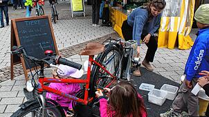 Kunsstoffbecher werden durch das fleißige Treten auf einem Fahrrad zerkleinert, um danach in der Presse zu neuen Gegenständen ...