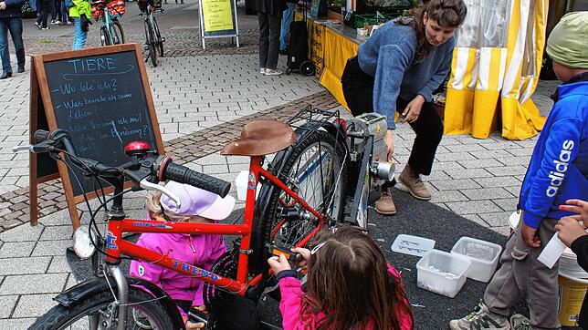 Kunsstoffbecher werden durch das fleißige Treten auf einem Fahrrad zerkleinert, um danach in der Presse zu neuen Gegenständen ...
