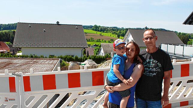 Philip, Janine und Christian Geller an ihrer Baustelle. Ob es mit dem Bau weitergeht, hängt an einem weiteren Kredit ihrer Bank.
