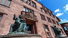 Statuen von Homer und Aristoteles stehen vor dem Kollegiengebäude 1 der Universität Freiburg.