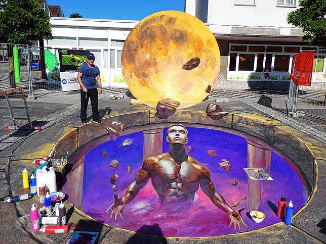 Das große 3D-Bild auf dem Blumberger Marktplatz malt Nikolaj Arndt 2019. Es zeigt einen Titan, der das Universum in seinen Händen trägt. ...