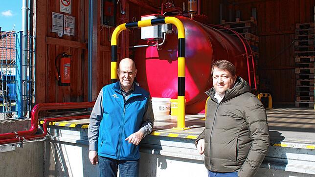 Dieter Hallerbach (links) und Felix Riegel an der betriebseigenen HVO-Tankstelle. Im Hintergrund steht der 5000-Liter-Tank mit Care-Diesel.