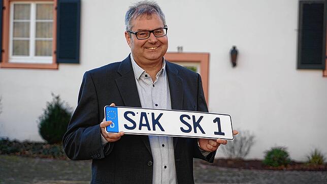 Alexander Guhl hält stolz das SÄK-Kennzeichen in den Händen, das sich der SÜDKURIER hat drucken lassen.