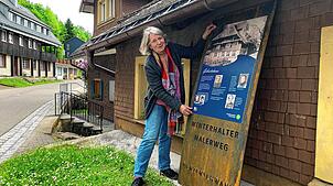 Elisabeth Kaiser hält vor dem Geburtshaus der Malerbrüder Winterhalter das Informationsschild an die neue Stele. Foto: Benedikt Reder