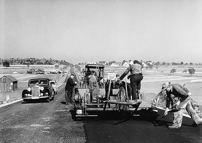 Eine Kolonne der Straßenbaufirma Storz arbeitet im Jahr 1957 auf der B 27 bei Balingen.