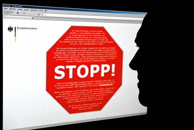 Ein Mann schaut am Computer auf eine Seite des Bundeskrimalamtes, auf der ein Stoppschild für eine Internetseite mit ...