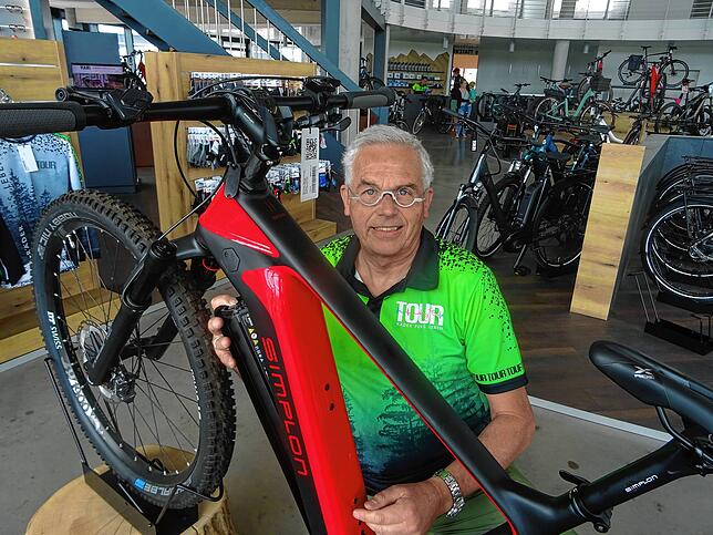 Martin Vetter, Inhaber des Fahrradladens Tour, öffnet an einem E-Bike jene Klappe, in dem der Akku verstaut ist.