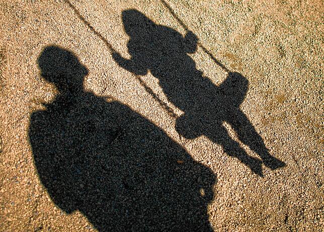 Der Schatten von einem Mann und einem schaukelnden Kind. (Symbolbild)