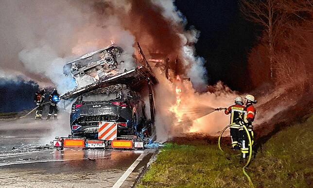 Rettungskräfte löschen auf der B 31 in der Dunkelheit einen brennenden Autotransporter.