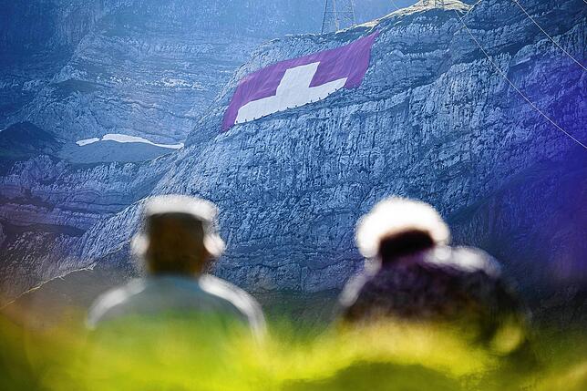 Die 80 mal 80 Meter große schweizerische Fahne ist von Weitem an einer Felswand unterhalb des Säntis zu sehen.