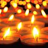 Many candle flames glowing in the dark, create a spiritual atmosphere