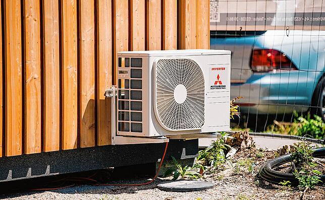 Eine Klimaanlage hängt außen an einem Wohnhaus.