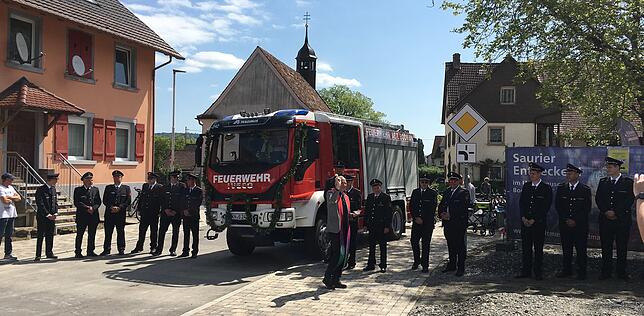 Die Fahrzeugweihe ist vorbei, nun bekommen auch die Feuerwehrkameraden noch ein paar Tropfen Weihwasser ab.