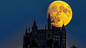 Der fast vollständige Vollmond hinter der Burg Hohenzollern am Freitagabend.
