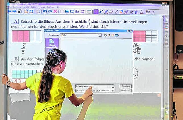Eine Schülerin einer sechsten Klasse steht vor einem Whiteboard. Das ist eine mit einem Computer verbundene digitale Tafel, an der man ...