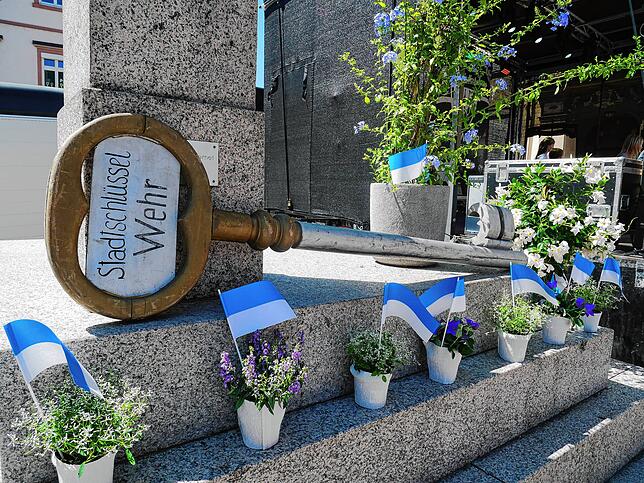Der Stadtschlüssel, Fahnen und Blumen in den Wehrer Farben Blau, Weiß und Grün.