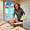 Ein Teil der Bücher ist bereits in der Stadtbibliothek, Kulturamtsleiterin Kerstin Simon öffnet für das Foto einen Umzugskarton.