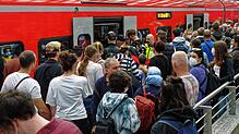 Reisende versuchen auf einem überfülltem Bahnsteig im Hauptbahnhof Köln in einen Regionalzug zu steigen.