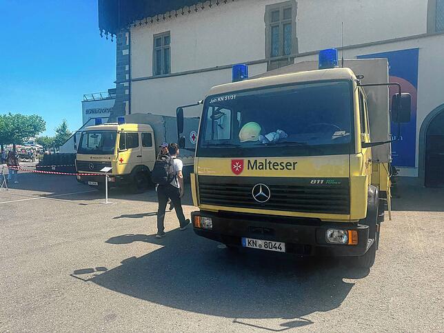 Am Konstanzer Konzil-Gebäude stehen die Einsatzfahrzeuge – unter anderem von Maltesern und Deutschem Roten Kreuz. Einige Helferinnen und ...