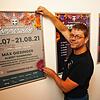 Jürgen Nägele, Mitveranstalter der Konstanzer Sommerwiese, hängt das diesjährige Plakat mit Autogramm von Max Griesinger ins Treppenhaus ...