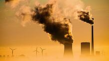 Windräder drehen sich neben einem Kohlekraftwerk. Die Umsetzung der Energiewende ist für viele Industriezweige fundamental wichtig, um ...