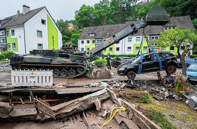 Nordrhein-Westfalen, Hagen: Soldaten der Bundeswehr bergen mit einem Pionierpanzer Dachs ein zerstörtes Auto bei den Aufräumarbeiten