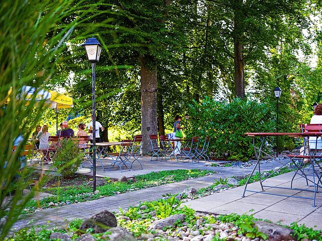 Der Biergarten hat zwar nur fast Seeblick, aber dafür gibt es viel Grünes drumherum.